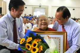 Lãnh đạo Thành phố Hồ Chí Minh trao Bằng chứng nhận danh hiệu "Bà mẹ Việt Nam Anh hùng” cho mẹ Lâm Thị Sảnh. (Ảnh: Hoàng Hải/TTXVN)