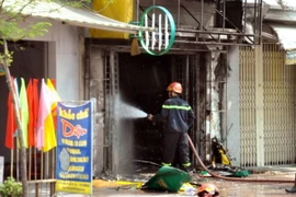 Lực lượng phòng cháy chữa cháy Quận 8 tiến hành dập lửa cửa hàng gas. (Nguồn: TTXVN phát) 