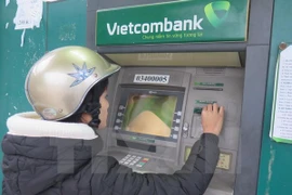 Khách hàng rút tiền tại ATM của Vietcombank. (Nguồn: TTXVN)