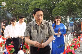 Thủ tướng Phạm Minh Chính thắp hương trên phần mộ liệt sỹ tại Nghĩa trang liệt sỹ quốc tế Việt - Lào. (Ảnh: Dương Giang/TTXVN)
