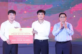 Thủ tướng Phạm Minh Chính trao cho đại diện huyện Anh Sơn kinh phí hỗ trợ xây dựng nhà tình nghĩa cho 20 gia đình thương binh, liệt sĩ. (Ảnh: Dương Giang/TTXVN)