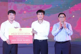 Thủ tướng Phạm Minh Chính trao cho đại diện huyện Anh Sơn kinh phí hỗ trợ xây dựng nhà tình nghĩa cho 20 gia đình thương binh, liệt sĩ. (Ảnh: Dương Giang/TTXVN)