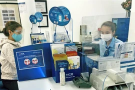 Khách hàng giao dịch tại Ngân hàng TMCP Quốc Dân. (Ảnh: Trần Việt/TTXVN)
