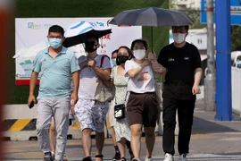 Người dân di chuyển dưới trời nắng nóng tại Thượng Hải, Trung Quốc ngày 10/7/2022. (Ảnh: THX/TTXVN)
