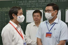 Bộ trưởng Bộ Giáo dục và Đào tạo Nguyễn Kim Sơn (trái) thăm và động viên tinh thần cán bộ làm công tác thi tại điểm thi trường THPT Đặng Huy Trứ, thị xã Hương Trà, tỉnh Thừa Thiên-Huế. (Ảnh: Mai Tran/TTXVN)