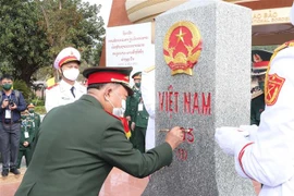 Đại tướng, Bộ trưởng Quốc phòng Lào Chansamone Chanyalath tô sơn cột mốc 605 tại cửa khẩu Lao Bảo tháng 12/2021. (Ảnh: Trọng Đức/TTXVN)