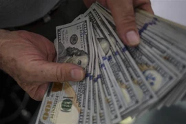 Kiểm tiền USB tại một quầy giao dịch tiền tệ. (Ảnh: AFP/TTXVN)