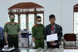 Đối tượng Giàng A Páo cùng tang vật tại cơ quan điều tra. (Ảnh: Đinh Thùy/TTXVN)