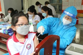 Tiêm vaccine phòng COVID-19 cho học sinh khối lớp 5 và lớp 4 tại điểm tiêm Trường Tiểu học Lê Văn Tám, thành phố Trà Vinh. (Ảnh: Thanh Hòa/TTXVN)