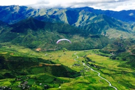 Dù lượn trên thung lũng Lìm Mông. (Ảnh: ChiLê/Vietnam+)