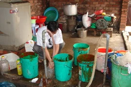 Các lu, thùng nằm ngổn ngang, dơ bẩn trong khu chế biến. (Ảnh: Dương Chí Tưởng/Vietnam+ )