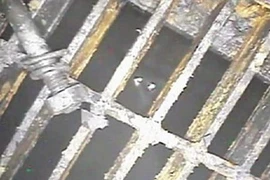 Hình ảnh chiếc bulông và lưới sắt dưới đáy bể chứa lò phản ứng trong video thu được từ camera nội soi của TEPCO tại lò phản ứng số 1. (Nguồn: Yomiuri)