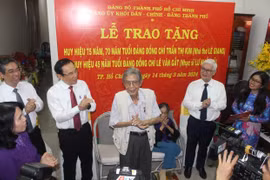 Bí thư Thành ủy Thành phố Hồ Chí Minh Nguyễn Văn Nên trao huy hiệu Đảng cho nhà thơ Lê Giang và nhạc sỹ Lư Nhất Vũ. (Ảnh: Chí Tưởng/TTXVN)