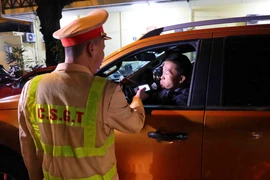 Cán bộ, chiến sỹ đội CSGT số 1 (Phòng CSGT Hà Nội) kiểm tra nồng độ cồn người điểu khiển phương tiện giao thông. (Ảnh: Phạm Kiên/TTXVN)