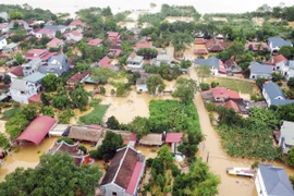 Hàng nghìn hộ dân dọc tuyến đường 32C ven theo sông Hồng thuộc các xã Tuy Lộc, Minh Tân bị nhấn chìm trong biển nước. (Ảnh: Tạ Toàn/TTXVN)