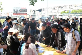 Các chủ quầy hàng bị thiệt hại trong vụ cháy TTTM Marywilska tập trung làm thủ tục nhận tiền hỗ trợ. (Ảnh: Ngọc Biên/TTXVN)