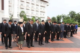 Cán bộ, nhân viên Văn phòng Thủ tướng Lào tưởng niệm Tổng Bí thư Nguyễn Phú Trọng tại Lễ Quốc tang. (Ảnh: Xuân Tú/TTXVN)