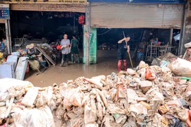 Những "núi" hàng hoá thành phế phẩm sau cơn lũ dữ. (Ảnh: Hoàng Hiếu/TTXVN)