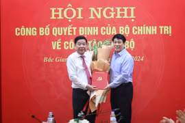 Ông Lương Cường (phải), Ủy viên Bộ Chính trị, Thường trực Ban Bí thư tặng hoa và trao quyết định cho đồng chí Nguyễn Văn Gấu nhận trọng trách mới. (Ảnh: Danh Lam/TTXVN)