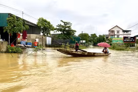 Người dân xã Kim Hoa, huyện Hương Sơn sử dụng thuyền để di chuyển trong vùng ngập nước. (Ảnh: Hữu Quyết/TTXVN)