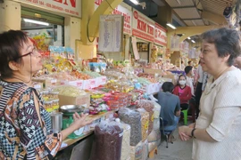 Lãnh đạo Sở An toàn thực phẩm Thành phố Hồ Chí Minh trao đổi với tiểu thương chợ Bình Tây về công tác đảm bảo an toàn thực phẩm. (Ảnh: Đinh Hằng/TTXVN)