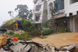 Đất ở dãy phố Tùng Tung ngày càng trồi lên cao khiến nhiều ngôi nhà bị xô nghiêng và có nguy cơ sập hoàn toàn. (Ảnh: Hương Thu/TTXVN)