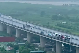 Khoảnh khắc ôtô lớn đi chậm trên cầu Nhật Tân để chắn gió cho xe máy