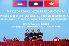 Các Chủ tịch Ủy ban điều phối chung 3 nước bắt tay thể hiện sự đoàn kết sau khi ký Biên bản Hội nghị Ủy ban điều phối chung lần thứ 13 Khu vực Tam giác phát triển CLV. (Ảnh: Phạm Kiên/TTXVN)