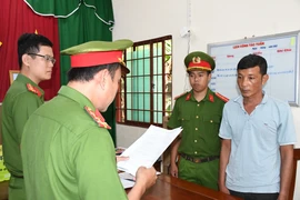 Cơ quan Cảnh sát Điều tra Công an tỉnh tống đạt các quyết định đối với bị can Nhan Thành Trung. (Ảnh: TTXVN phát)