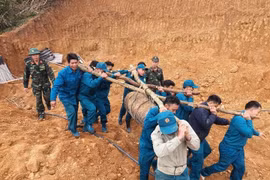 Lực lượng chức năng di chuyển quả bom đến khu vực an toàn để tiến hành hủy nổ. (Nguồn: VTCNews)