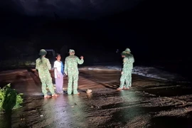 Bộ đội Biên phòng tỉnh Quảng Bình tuyên truyền, nhắc nhở người dân huyện Minh Hóa không qua các ngầm tràn khi nước lũ dâng cao. (Ảnh: TTXVN phát)