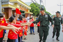 Nhân dân hai bên đường Võ Nguyên Giáp động viên, cổ vũ cho các lực lượng tham gia diễu binh, diễu hành. (Ảnh: Trung Kiên/TTXVN)