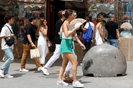 Người dân di chuyển dưới trời nắng nóng tại Madrid, Tây Ban Nha. (Ảnh: AFP/TTXVN)