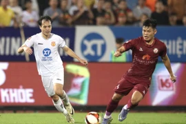 Tiền đạo Văn Toàn (Thép Xanh Nam Định) tranh chấp bóng với cầu thủ MerryLand Quy Nhơn Bình Định. (Ảnh: Công Luật/TTXVN)