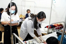 Cán bộ Trung tâm Kiểm soát bệnh tật lấy mẫu máu xét nghiệm. (Ảnh: Công Tường/TTXVN)