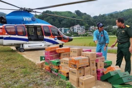 Chuyển hàng cứu trợ từ trực thăng xuống vùng lũ thuộc huyện Nguyên Bình, Cao Bằng. (Ảnh: Thông tấn Quân sự/TTXVN phát)