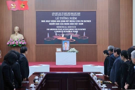 Các đại biểu dành phút mặc niệm bà Merle Evelyn Ratner. (Ảnh: An Đăng/TTXVN)