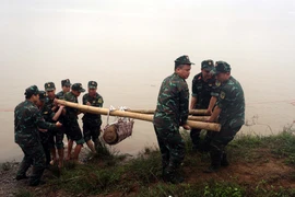 Lực lượng công binh tỉnh Hưng Yên di dời quả bom về nơi hủy nổ. (Ảnh: Đinh Văn Nhiều/TTXVN)