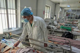 Bác sỹ thăm khám bệnh nhân sau phẫu thuật. (Ảnh: TTXVN phát)