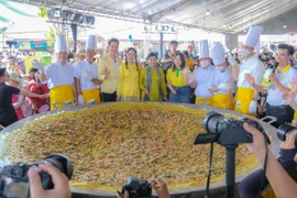 Chế biến chiếc bánh xèo khổng lồ với đường kính 3m phục vụ khách tham quan lễ hội ngày 18/4. (Ảnh: Thanh Liêm/TTXVN)