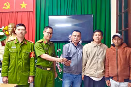 Công an phường 3 trả lại chiếc ví cho du khách ông Nguyễn Lê Trãi, 52 tuổi, trú tại huyện Diên Khánh, tỉnh Khánh Hòa trước sự chứng kiến của anh Thương và ông Khánh. (Ảnh: TTXVN phát)