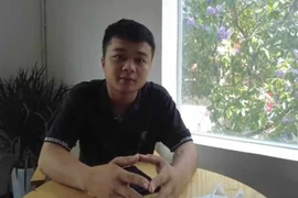 Hoàng Anh Tuấn không ngại nguy hiểm, đập tường tạo ra một lỗ thủng để cứu những nạn nhân trong vụ cháy. (Ảnh Mạnh Khánh/TTXVN)