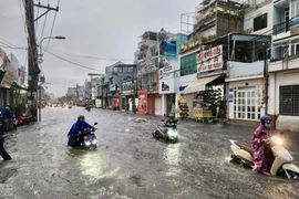 Nước ngập lút bánh xe mô tô trên đường Kha Vạn Cân (thành phố Thủ Đức, Thành phố Hồ Chí Minh). (Ảnh: Hồng Giang/TTXVN)