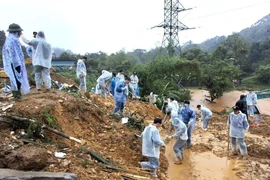 Cán bộ, chiến sỹ Công an tỉnh Hà Giang và các lực lượng chức năng nỗ lực tìm kiếm nạn nhân mất tích trong vụ sạt lở nghiêm trọng. (Ảnh: TTXVN phát)