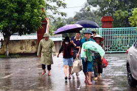 Cán bộ chính quyền địa phương hộ trợ người dân di dời trước nguy cơ sạt lở núi cây Sường (thị trấn Quy Đạt, huyện Minh Hóa). (Ảnh: Tá Chuyên/TTXVN)