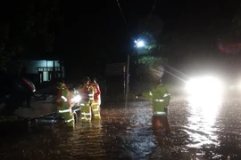 Lực lượng cảnh sát giao thông đưa canô đến những điểm ngập sâu tại thành phố Đồng Hới, Quảng Bình để di tản người dân đến nơi an toàn. (Ảnh: Đức Thọ/TTXVN) 