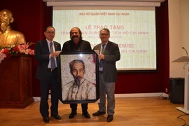 Nghệ sỹ Mustapha Boutadjine (giữa) cùng nhà sử học Alain Ruscio (phải) trao tặng cho Đại sứ Việt Nam tại Pháp Nguyễn Ngọc Sơn bức tranh chân dung Chủ tịch Hồ Chí Minh. (Ảnh: Bích Hà/Vietnam+)