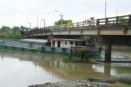 Hiện trường sà lan bị mắc kẹt vào cầu Ông Cộ. (Ảnh: Huyền Trang/TTXVN)