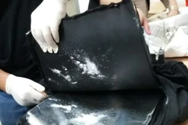 Ma túy được phát hiện dưới đáy túi xách. (Ảnh: Hoàng Hải/Vietnam+)