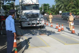 Kiểm tra tải trọng xe tại Trạm cân xe lưu động Tiền Giang. (Ảnh: Minh Trí/TTXVN)